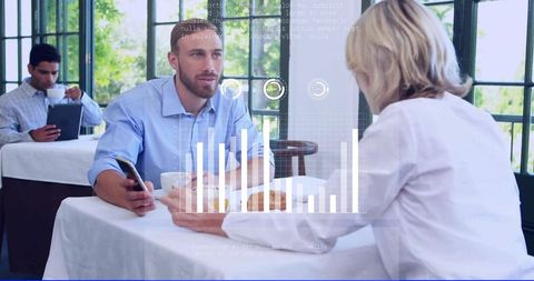 Discussing business over coffee with digital analytics overlay and mobile collaboration