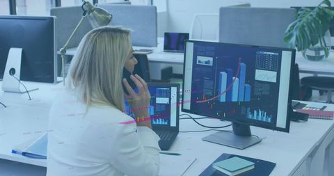 Businesswoman Analyzing Financial Data on Office Screens