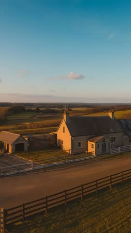 Drone hovering and panning over farmhouse, barn and outbuildings across rolling fields