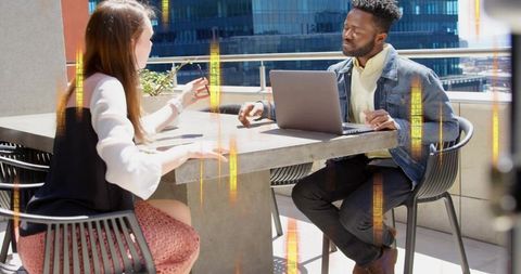 Rooftop coworking meeting discussing strategy with laptop, gesturing, urban cityscape