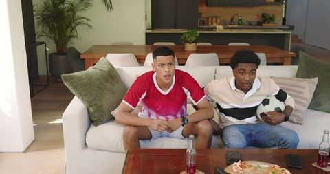 Friends Excitedly Watching Soccer Game on TV in Modern Living Room