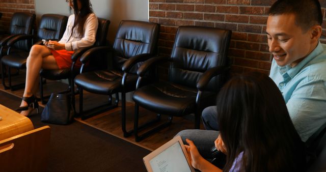 Father and Daughter Relaxing in Waiting Room Looking at Tablet - Download Free Stock Images Pikwizard.com