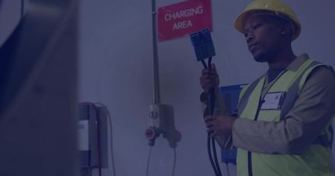 Technician plugging heavy-duty charger connector in warehouse charging area