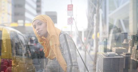 Asian Woman in Hijab Catching Taxi in Urban Landscape