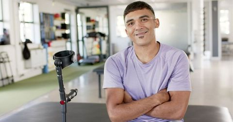 Man in rehabilitation center with crutches smiling confidently