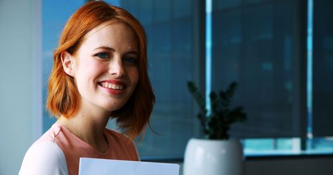 Confident Young Businesswoman Smiling with Documents in Modern Office - Download Free Stock Images Pikwizard.com