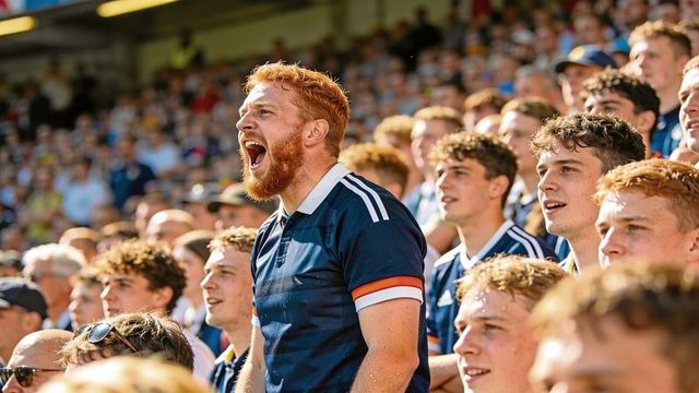Red-haired bearded fan shouting passionately in crowd of supporters during matchday