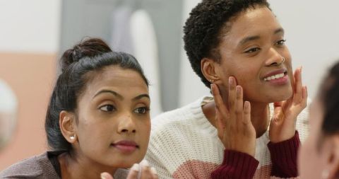 Diverse friends practicing skincare at home