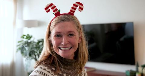 Smiling woman wearing festive candy cane headband