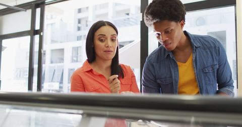 Diverse customers choosing food at bistro shop counter