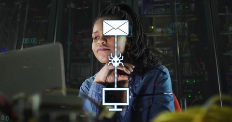 It specialist monitoring malware and email phishing alerts on laptop in dark server room
