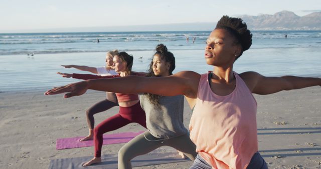 A diverse group of women doing yoga poses on a beach during early morning. They stretch and balance, focusing on fitness and mindfulness in a serene seashore setting. Ideal for promoting wellness programs, fitness retreats, meditation, outdoor workouts, and healthy lifestyles.