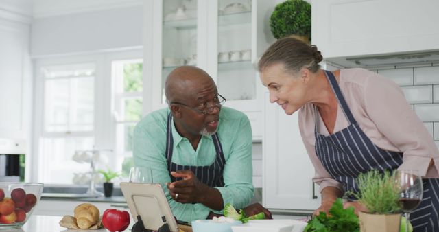 Happy Senior Couple Cooking and Looking at a Recipe Tablet in Modern Kitchen - Download Free Stock Images Pikwizard.com