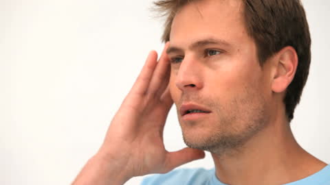 Man Experiencing Intense Headache Holding Head in Pain