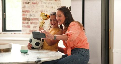 Mother and Daughter Celebrating Sports Victory with Selfie