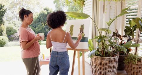 Woman Painting on Canvas Outside with Caffeinated Companion