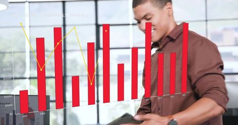 Business professional using tablet with monthly revenue bar chart and line graph