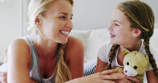 Smiling Mother and Daughter with Teddy Bear Relaxing in Bed - Download Free Stock Images Pikwizard.com