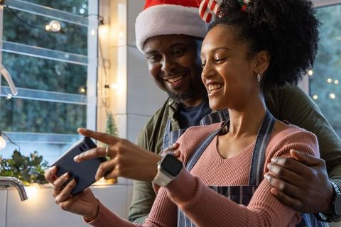 African american couple sharing holiday baking joy in cozy kitchen, smiling together