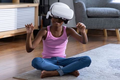 African american girl exploring virtual reality at home wearing vr headset