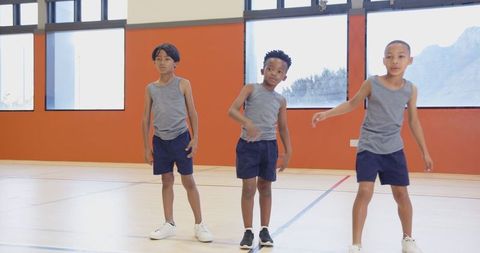Cheerful children exercising in gym together