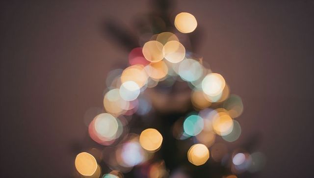 Glowing bokeh christmas tree lights creating cozy festive blur with multicolor warm glow