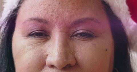 Close-up mature woman wearing white fur hat, subtle eyeshadow, natural skin texture