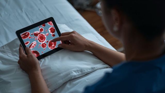 Healthcare professional studying red blood cells on tablet at bedside for telemedicine
