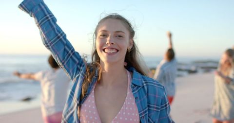 Smiling Woman Celebrating Joyful Beach Moment at Sunset