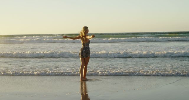 Woman Embracing Ocean with Outstretched Arms on Beach at Sunset - Download Free Stock Images Pikwizard.com