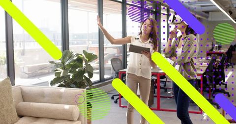 Women collaborating in modern office with tablet and vr, neon graphic overlay
