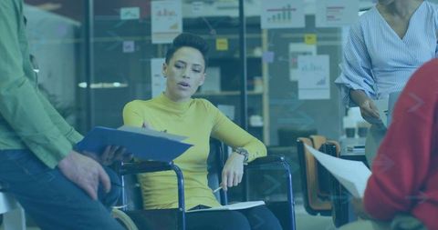 Leading woman in wheelchair guiding team meeting in modern office for inclusive leadership