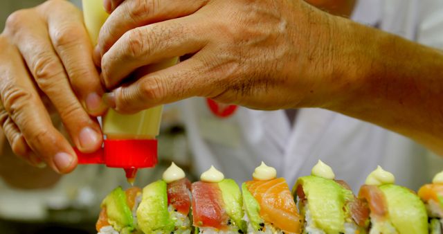 Chef adding finishing touches to sushi rolls, ideal for culinary blogs, Japanese cuisine features, restaurant websites, and food preparation magazines emphasizing fine dining and professional cooking skills.