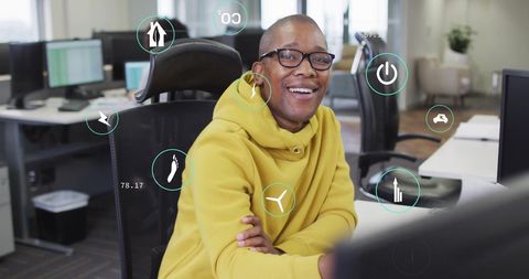 Smiling Professional with Data and Eco Icons in Modern Office