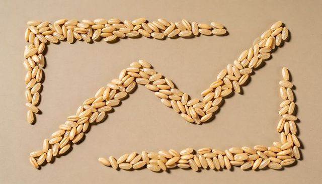 Arranging brown rice kernels into geometric frames and zigzag pattern on beige surface