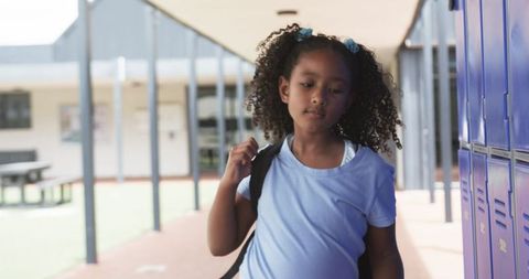 Biracial Girl Holding Book by School Lockers in Slow Motion - Download Free Stock Images Pikwizard.com