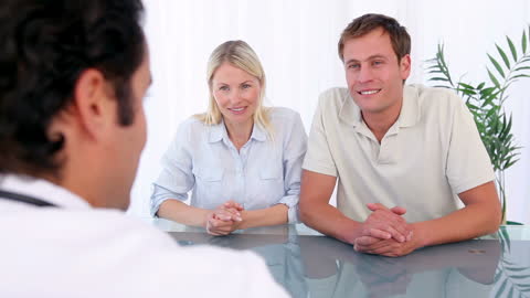 Couple Consulting with Doctor in Bright Modern Office