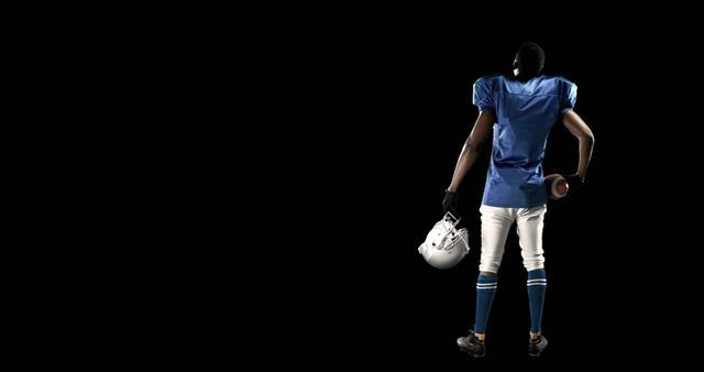 American Football Player in Blue Jersey Holding Helmet and Ball - Download Free Stock Images Pikwizard.com