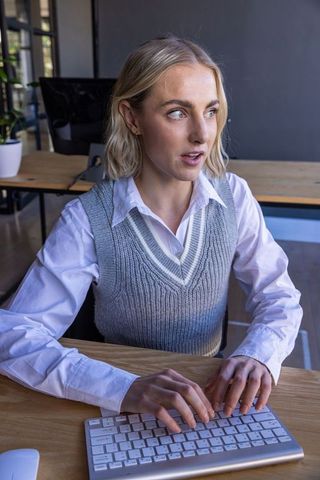 Focused Woman Typing at Computer in Modern Office Space