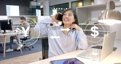 Smiling businesswoman making international currency call with dollar and yen graphics