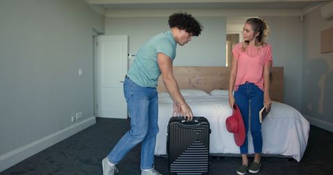 Young Couple Packing Suitcase Preparing for a Trip in Bedroom
