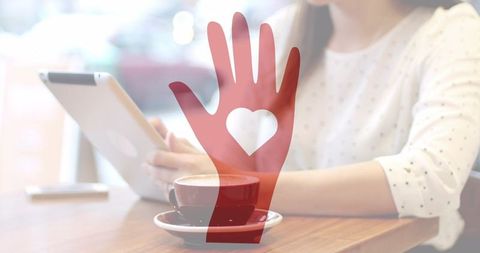 Middle-Aged Woman Using Tablet in Cozy Cafe Setting with Coffee