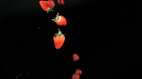 Floating Red Berries Against Dark Background
