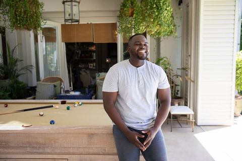 Man Relaxing on Veranda with Billiards Table Surrounded by Greenery