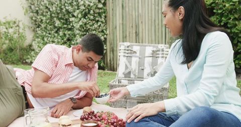 Young Couple Enjoying Outdoor Picnic in Sunny Park