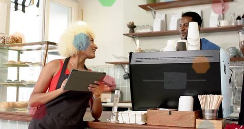 Barista using tablet at modern cafe counter
