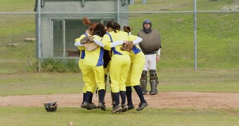 Female softball team celebrating victory unity outdoors