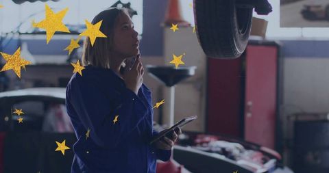 Female auto technician inspecting vehicle underside in garage