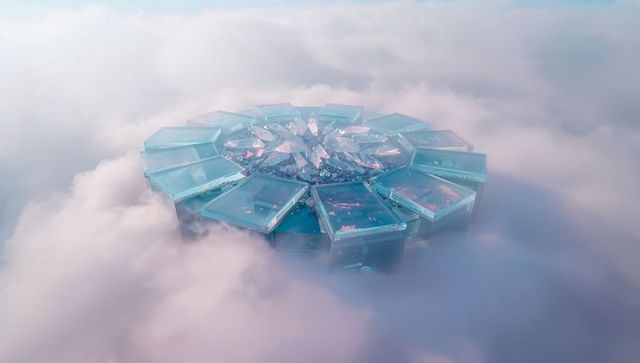 Futuristic prism structure floating above clouds