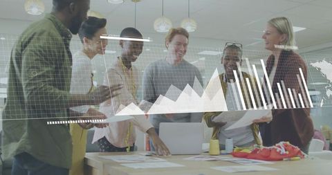 Multicultural Creative Team Collaborating Around Table Reviewing Data Charts and Designs